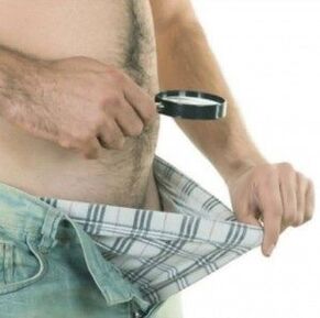 muž se dívá dolů do kalhot a chce si zvětšit penis gelem